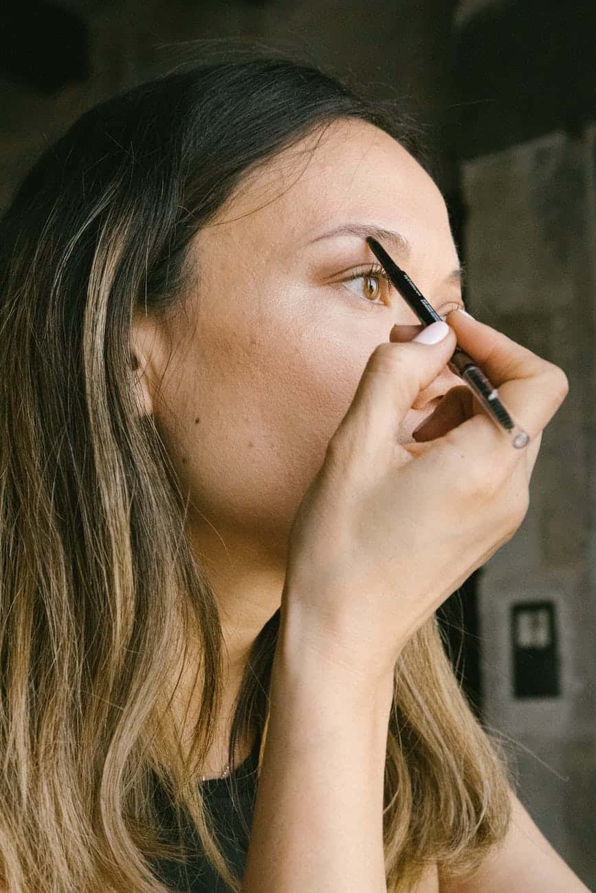 woman holding eyebrow pencil