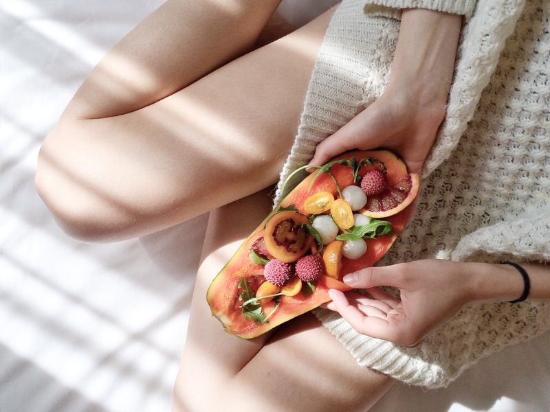 Woman on bed with healthy food