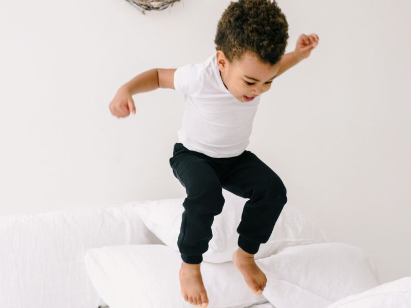 child jumping on bed