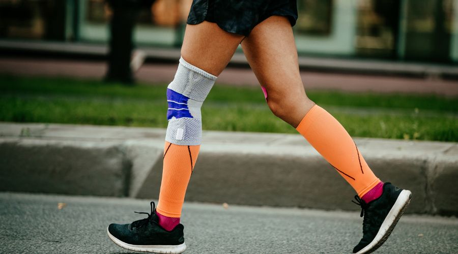 Woman running in orange compression socks