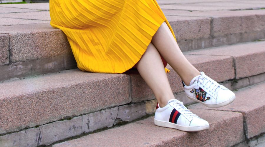 Woman sitting on a step and wearing a yellow skirt 